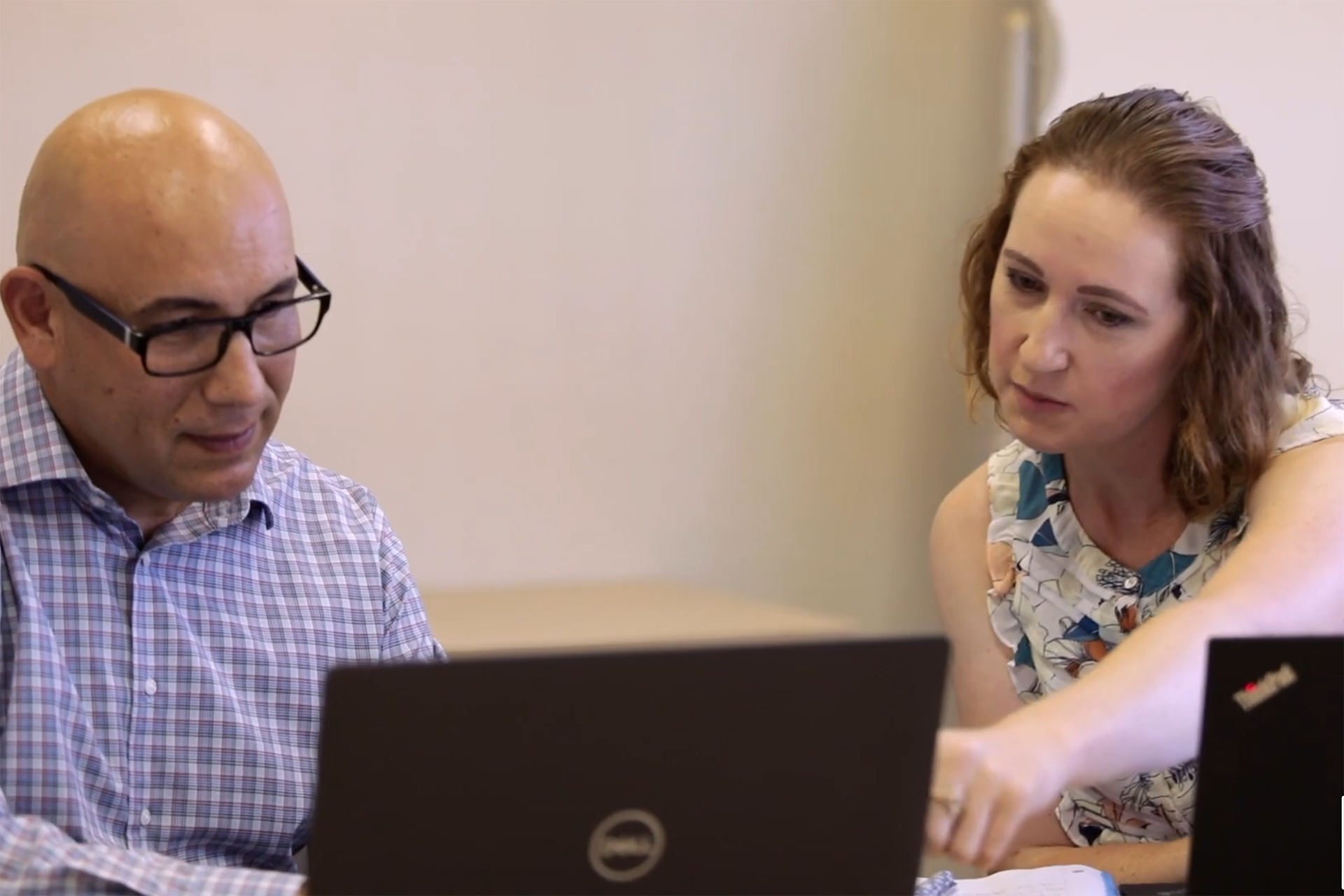 A job seeker working with her career coach to update a resume on a lap top.