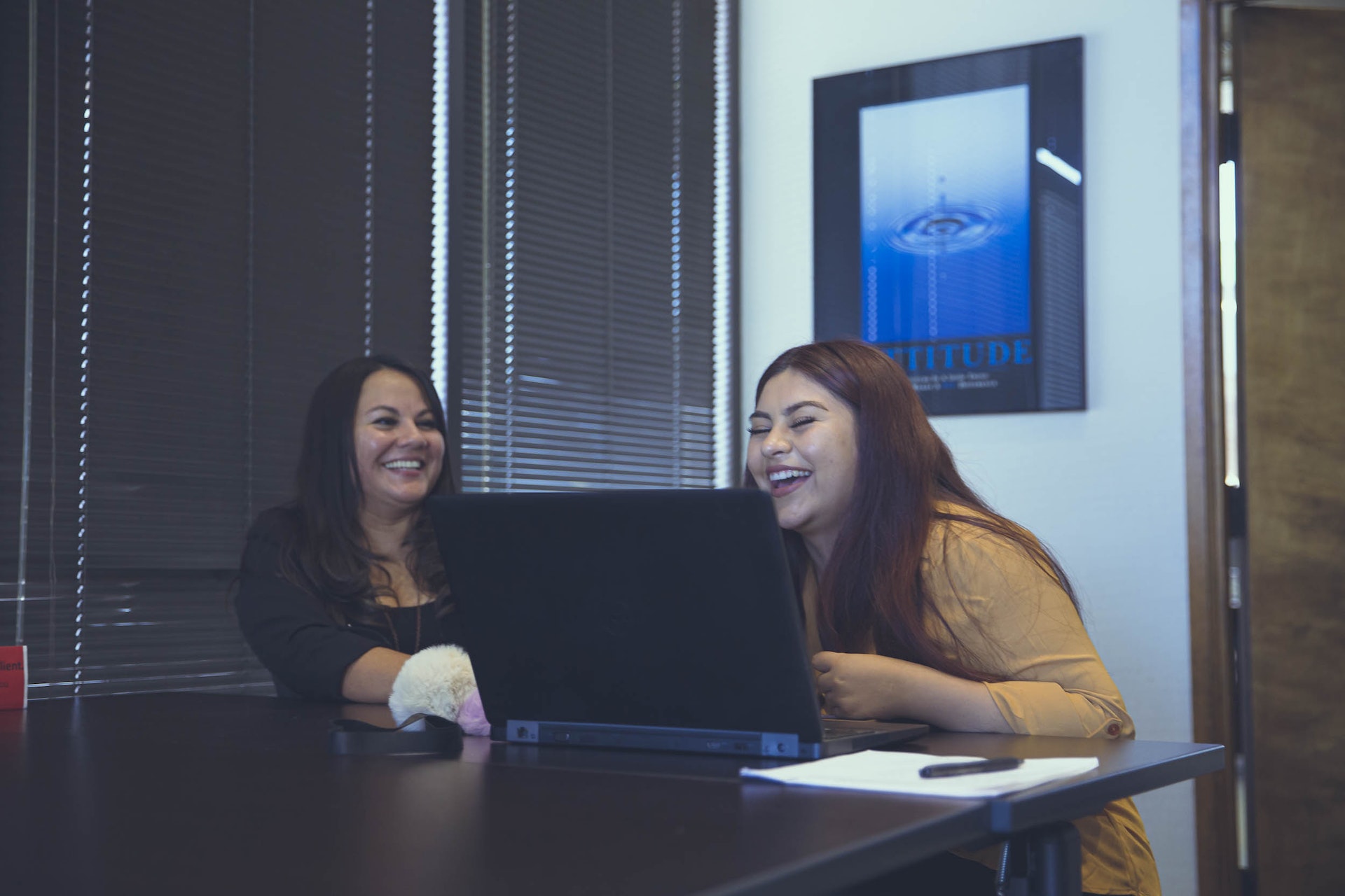 A job seeker and career coach laughing as they work at a computer