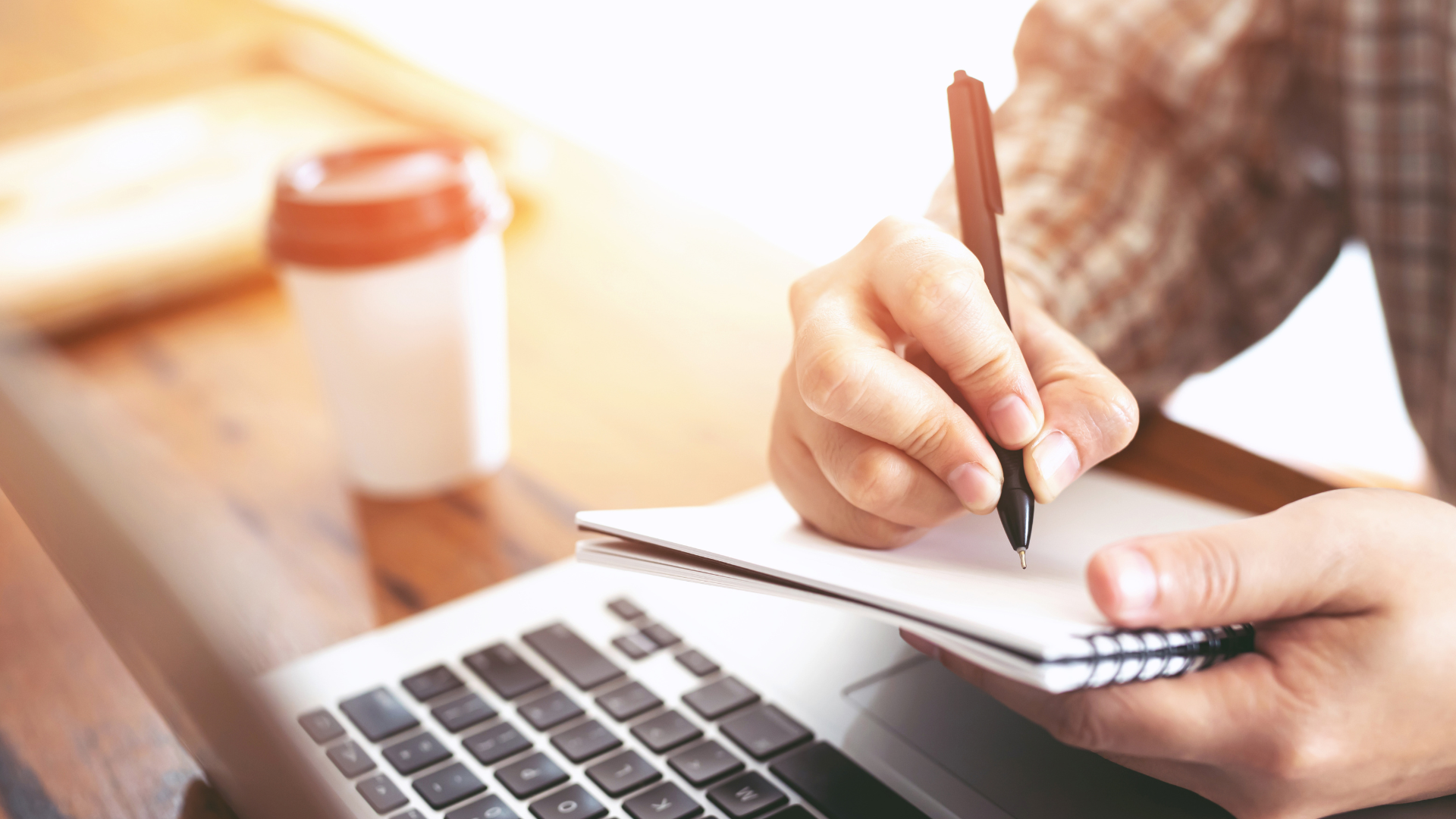 A man using a pen to write in a notebook.