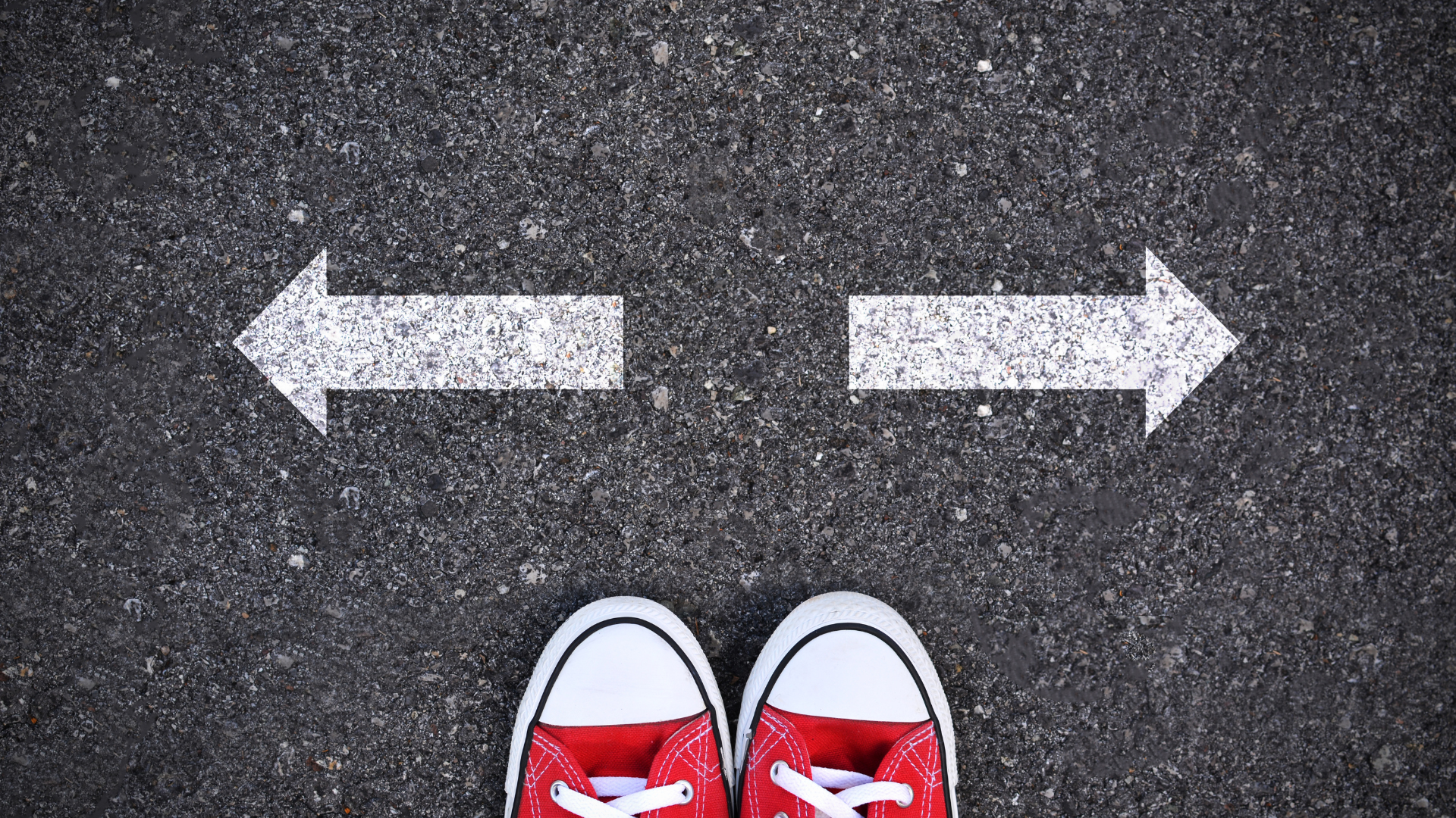 two feet on a road with arrows pointing in opposite directions