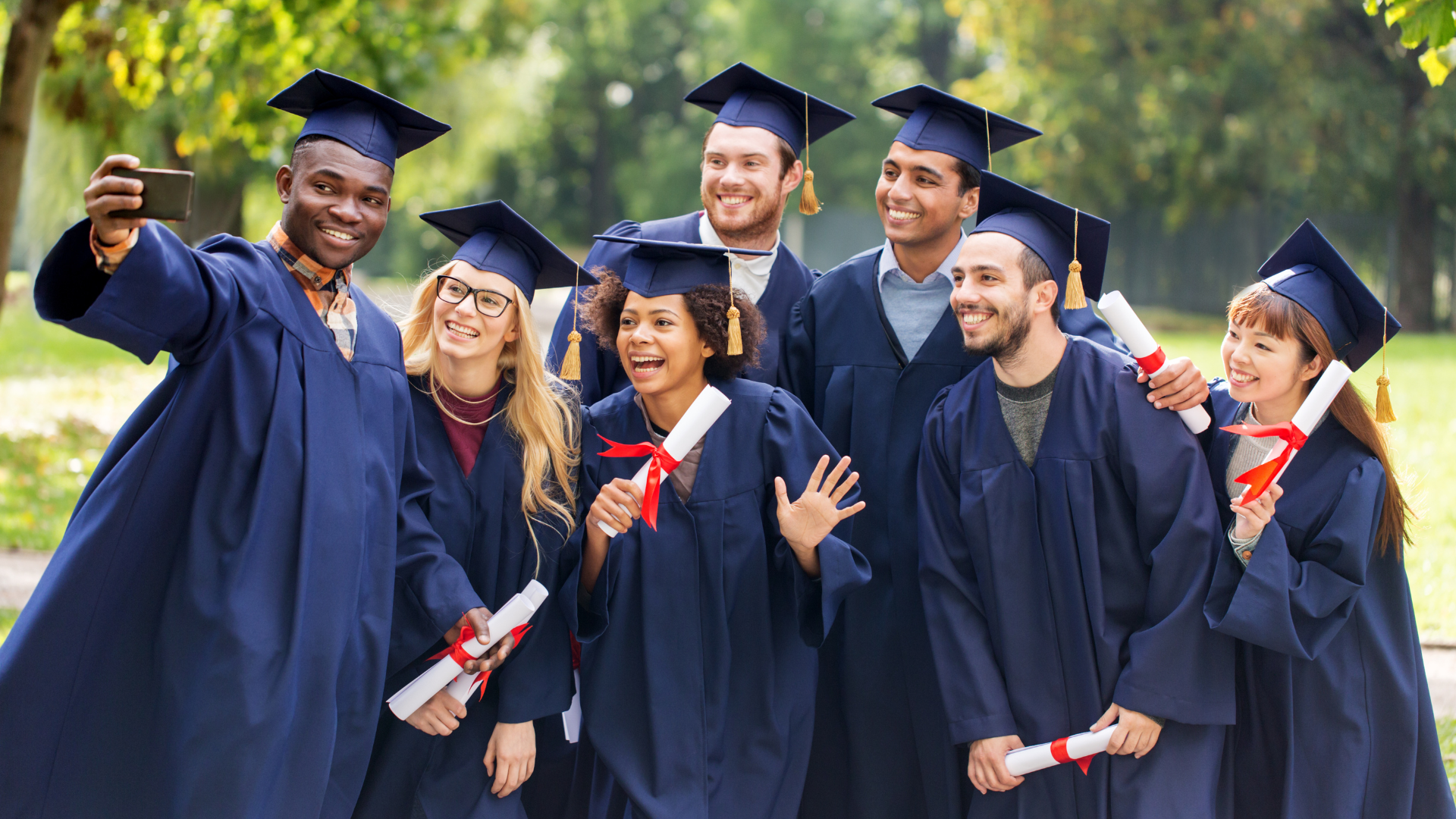 Group of graduates in caps and gowns taking a group photo.
