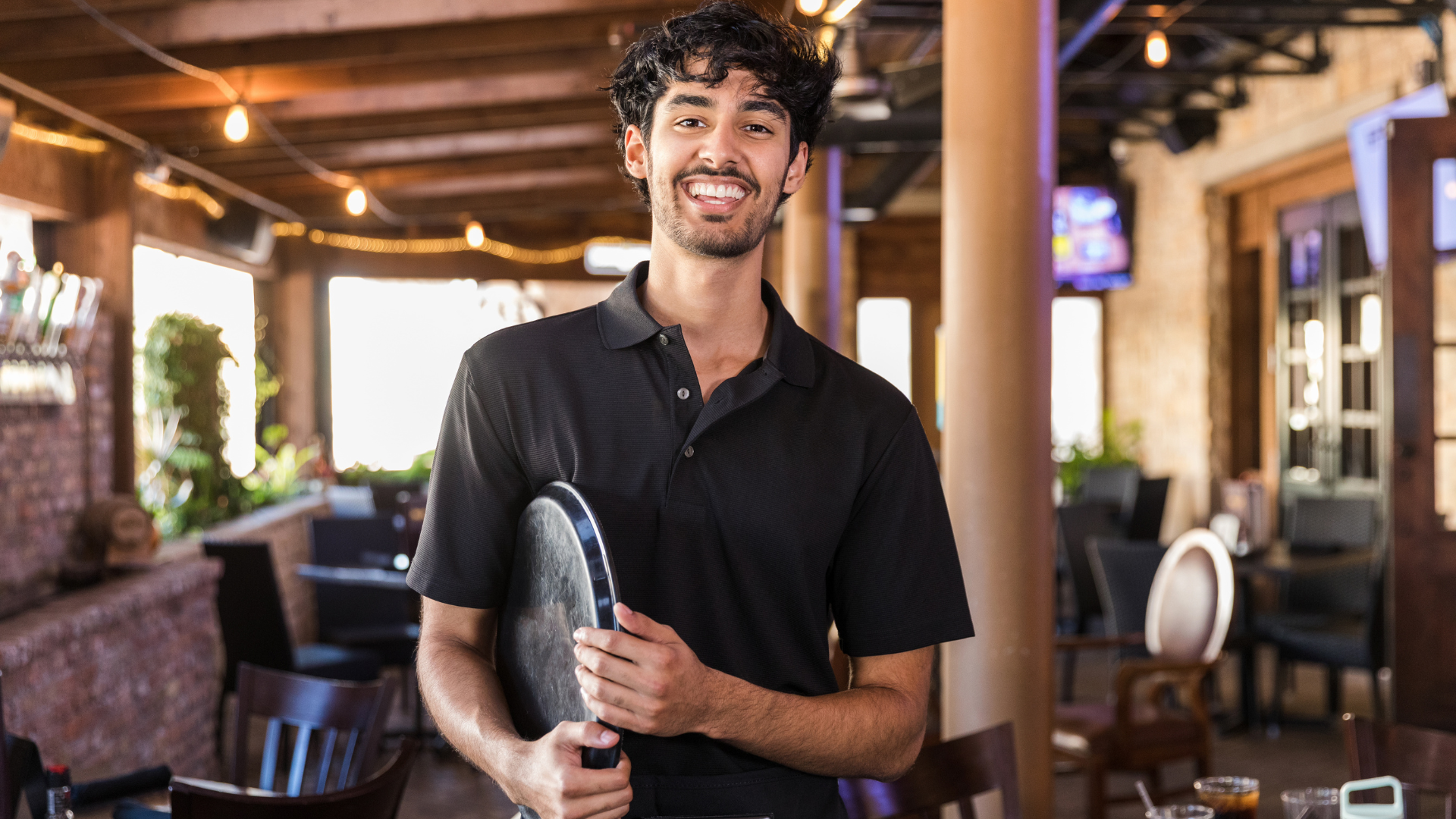 Young male waiter carrying a tray