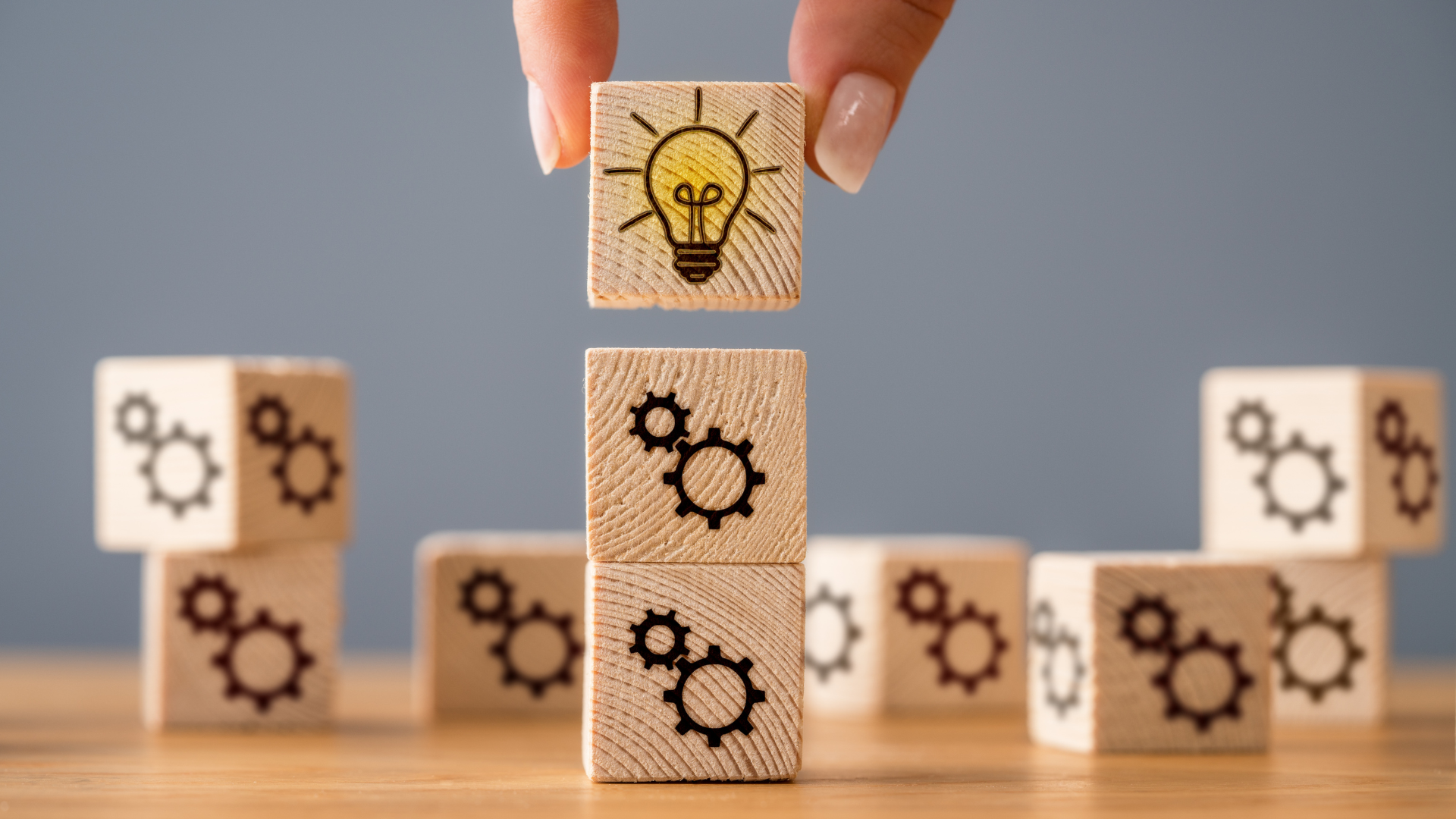 wooden blocks with images of gears and a light bulb