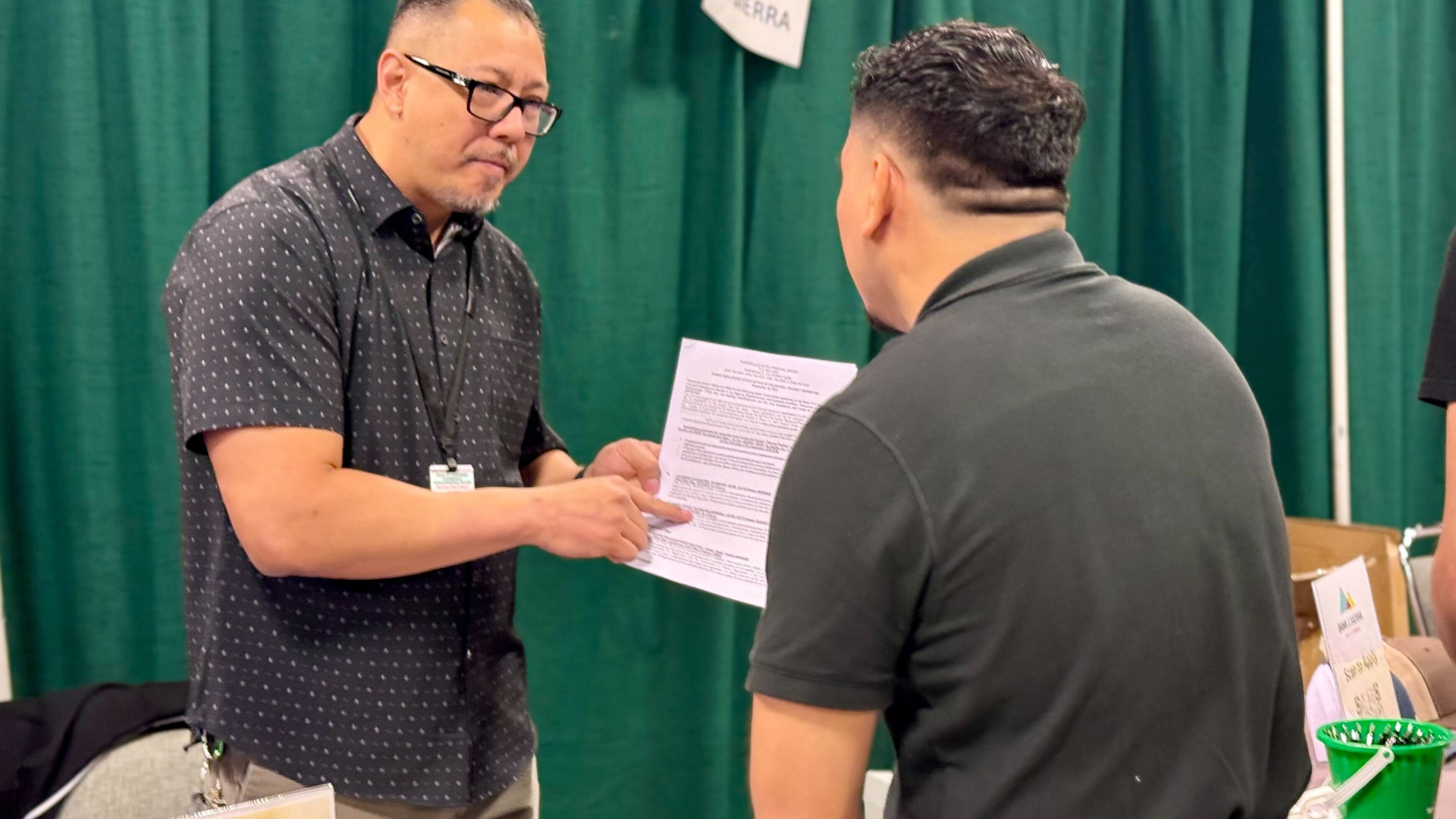 Two men looking at a resume